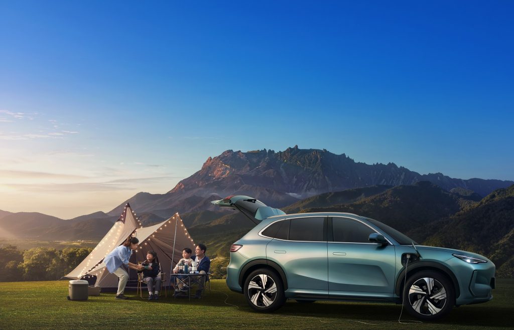 Proton e.MAS 7 elektrik diparkir di kawasan pergunungan dengan aktiviti perkhemahan keluarga