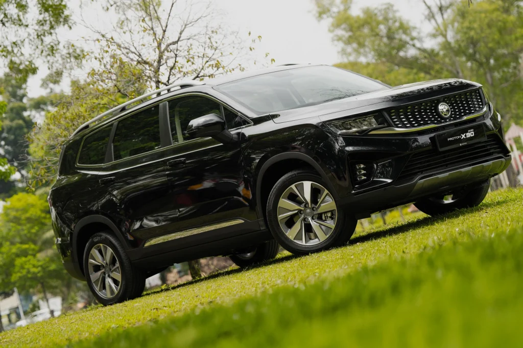 Proton X90 hitam 2026 dipandu di kawasan hijau sempena Promosi X90 Mei 2026 untuk SUV premium 7-seater Malaysia